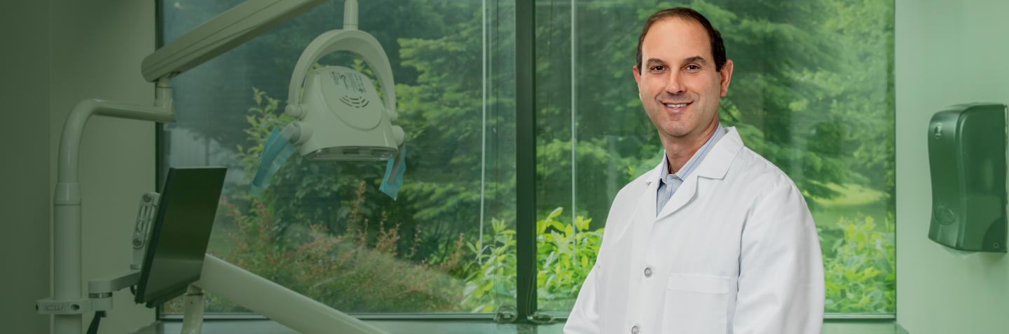 Dr. Adam Klein, dentist at Monroe Dental Group, standing in a treatment room